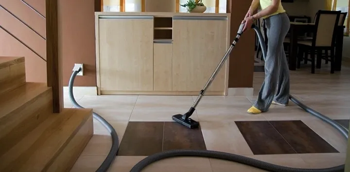 woman vacuuming tile with portable vacuum